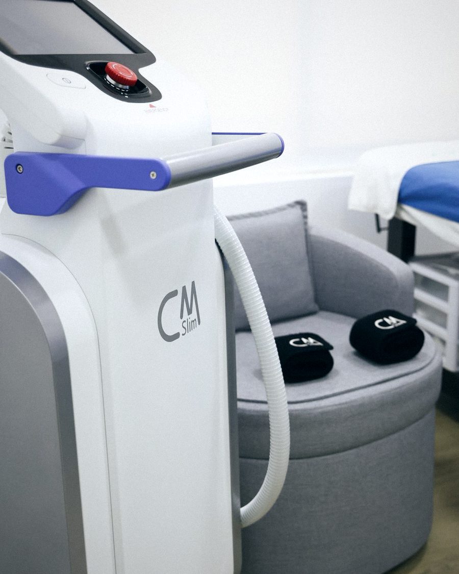 An electromagnetic body sculpting device beside a treatment chair at Dreambody